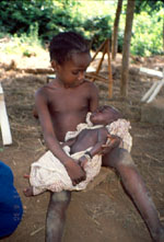 60. Tupé holding second cousin baby Kouadio, who was born with a herniated testicle
