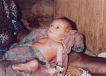 16. Newborn wearing a necklace and knee band