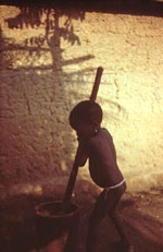 14. Toddler pounding food in a mortar